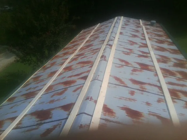 Rusted metal roof panels with new wood purlins before replacement — Storm Damage Roof Repair in Montross by Roofing Brothers