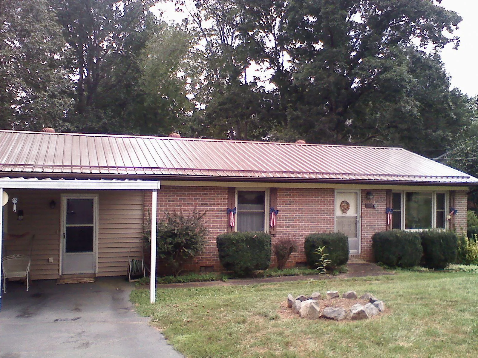 Bronze metal roof and carport on a brick ranch home — Roof Repair work by our crew in Montross