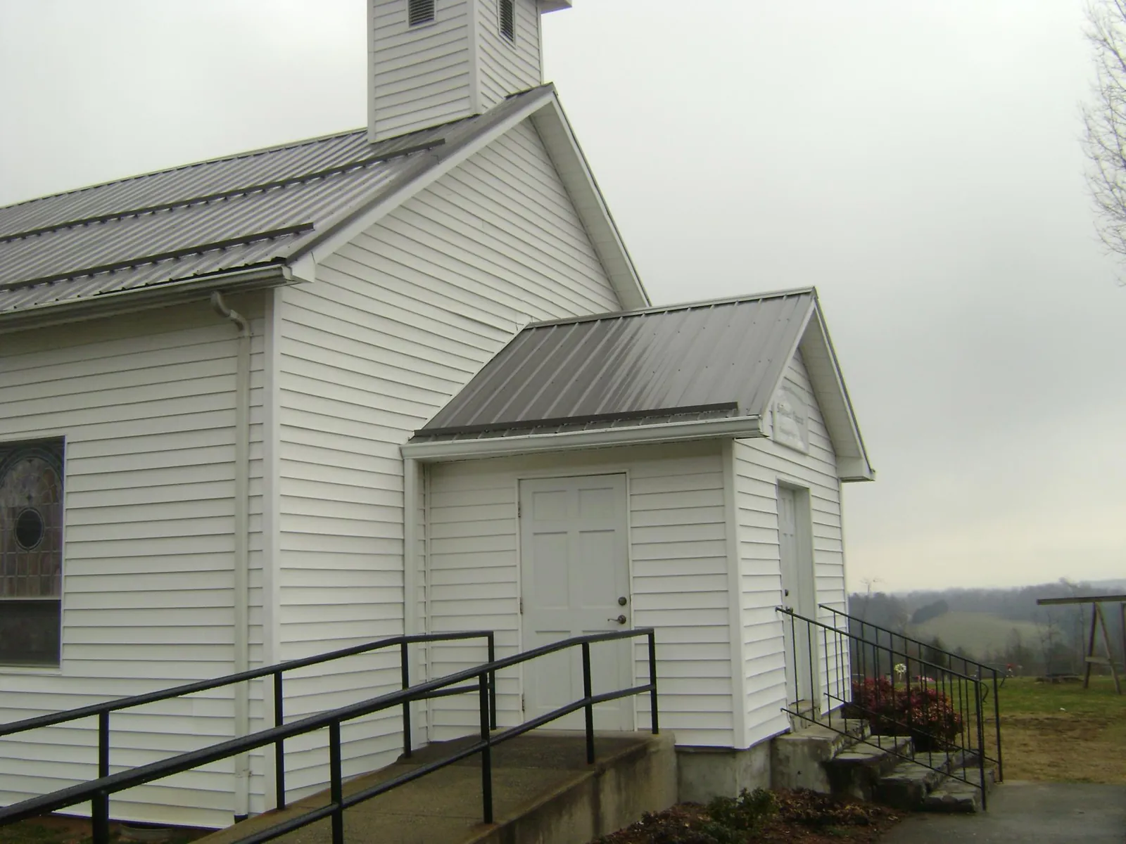 Gray metal roof on a white clapboard church with a steeple in Montross